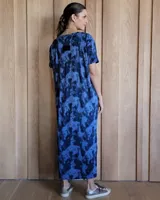 Vestido negro de corte recto, largo midi, con escote en V y mangas cortas.