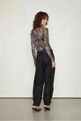 Pantalón negro con estampado de piel de serpiente, de tiro bajo y corte holgado, con puños ajustables con lazos.