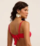 Top de bikini bandeau color rojo, confeccionado en microfibra acanalada. Tiene breteles ajustables y removibles, nudo en el centro, copa removible y lazo en la espalda.