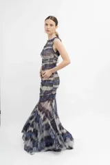 Vestido midi de microtul estampado tipo batik en tonos lavanda, verde y negro. Diseño ajustado con frunces y forro en todo el cuerpo. Falda transparente con terminación en picos.