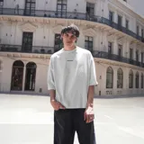 Remera blanca de algodón con estampado en la espalda que incluye el logo de la marca VENEFO, texto descriptivo y un dibujo del planeta tierra.