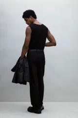 Musculosa negra de punto acanalado, con corte ajustado y ribete acanalado fino en escote, sisas y bajo.