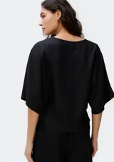 Blusa color crema con escote en V y mangas cortas amplias.