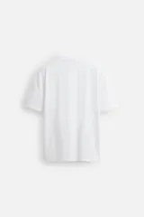 Camiseta blanca de algodón de peso medio, corte slim fit, cuello redondo y manga corta.