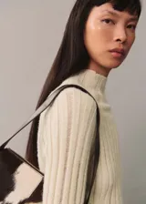 Sweater color hueso de tejido de punto acanalado con cuello perkins y mangas largas acampanadas.