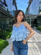 Blusa celeste con tirantes finos, escote en V con detalle de encaje y volados en capas.