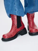 Botas negras de cuero con diseño floral en relieve, corte Chelsea, elásticos laterales, plataforma delantera de 2cm y tacón de 5,5 cm.