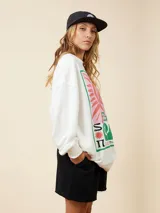 Sweater blanco con estampado de sol, olas y texto en rosa y verde.