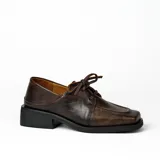 Zapato acordonado de cuero vacuno color marrón oscuro, con suela de goma, horma cuadrada y tacón bajo.