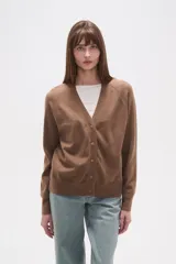 Cardigan holgado de tejido de punto color gris, con escote en V, cierre frontal de botones y detalles calados en las mangas raglán.