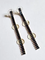 Par de aros colgantes con base dorada y strass azul oscuro.
