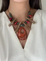 Collar largo con tiento sintético ajustable, cuentas de cerámica y medallones grandes de resina color marrón, blanco y azul.