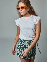 Falda short negra con estampado geométrico en color beige, con detalle de lazo lateral.