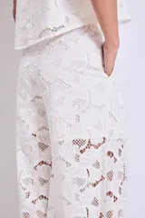 Pantalón palazzo blanco de broderie con cintura alta y pierna ancha.
