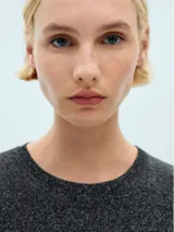 Remera negra con brillo, de tejido de punto fino y manga larga.