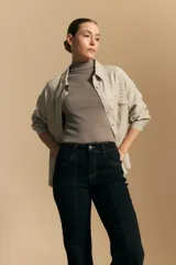 Jean oxford de tiro alto, color azul oscuro, con costuras frontales marcadas y corte acampanado progresivo desde la rodilla.