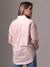 Camisa de popelín de algodón color rosa claro, de corte holgado, con cuello clásico, cierre frontal con botones, bolsillo de parche en el pecho y puños abotonados.