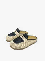 Mules artesanales tejidas a mano en raffia color beige y negro, con diseño cómodo y flexible, suela liviana y estilo relajado.