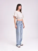 Blusa corta a rayas horizontales color beige y blanco, con mangas cortas con volados y elástico en la cintura.