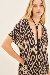 Vestido corto de viscosa con estampado ikat en tonos beige y marrón. Tiene corte amplio y escote en V.