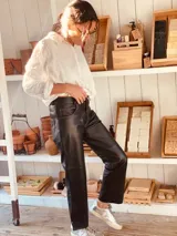 Pantalón negro de cuero ovino italiano, corte mom fit con tiro semi alto y tajos inferiores.