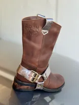 Bota de cuero marrón con estribo desmontable plateado.