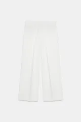 Pantalón blanco de tiro alto y pierna ancha, con cierre lateral oculto.
