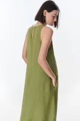 Vestido largo blanco de lino, sin mangas y con bolsillos laterales.