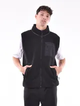 Chaleco negro de polar con cierre frontal y cuello alto. Tiene un bolsillo con cierre en el pecho y bolsillos laterales.