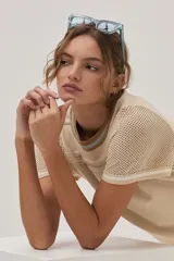 Vestido midi de tejido de punto color beige, con escote redondo, mangas cortas, tajos laterales y diseño con patrón de puntos calados y rayas.