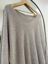 Sweater beige de tejido de punto, con escote en pico y corte recto.