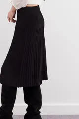 Falda midi negra de tejido de punto con cintura elastizada y diseño plisado.