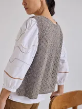 Chaleco de tejido calado color verde oliva, sin mangas y con cuello redondo.