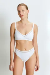 Conjunto de ropa interior blanca, compuesto por un corpiño triangular con breteles regulables y detalle de malla en el escote, y una bombacha vedetina de tiro alto con detalle de malla en la cintura.