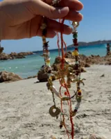 Collar con dije de bronce macizo con forma orgánica o de coral, suspendido de un hilo de seda natural color naranja.