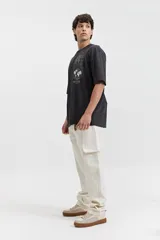 Pantalón cargo color crudo, de corte recto, con bolsillos laterales y traseros.