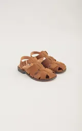 Sandalias bajas de cuero marrón con tiras entrecruzadas y hebilla dorada.