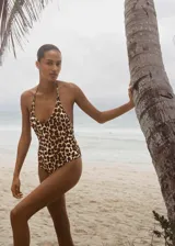 Traje de baño enterizo con estampado animal print de leopardo en tonos marrones y negros. Tiene escote en V, espalda descubierta y tirantes finos que se atan al cuello.