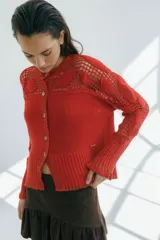 Cárdigan de algodón color crudo, con calce entallado y tejido acanalado. Presenta detalles de crochet hechos a mano, mangas con volados y vivos de color en cuello, puños y frente.