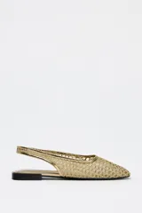 Zapato plano destalonado tipo bailarina color dorado, con capellada de malla trenzada, estilo mule y tira trasera con pieza elástica.