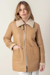 Campera de cuero color camel con cuello y puños de piel sintética color crema. Cierre frontal con cremallera y bolsillos laterales.