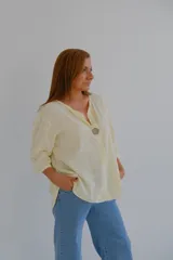 Blusa color amarillo pálido de corte holgado, con escote en V y mangas 3/4.