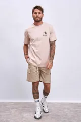 Remera color beige con estampado pequeño en el pecho.