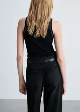 Musculosa verde oscuro de punto canalé con ribetes en contraste.