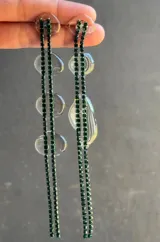 Aros colgantes largos con strass verde esmeralda y detalles de resina transparente.