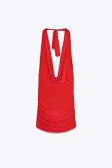 Vestido corto rojo confeccionado en tejido fluido, con cuello halter con lazada, escote drapeado, espalda descubierta y detalle de frunces.