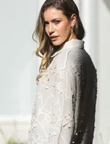 Camisa de algodón color crema, marca Liv Los Angeles, con bordado floral y terminaciones en crochet en puños y ruedo. Tiene cuello con solapa y abertura central con botones.