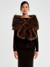 Chal envolvente de pelo sintético color marrón, con diseño cruzado sobre los hombros y textura suave y voluminosa.