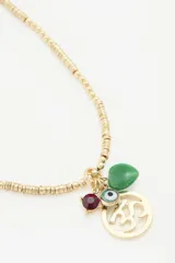 Collar dorado con cadena de lentejuelas metálicas y dijes colgantes: símbolo Ohm calado, cuenta roja, cuenta verde en forma de corazón y dije de ojo turco.