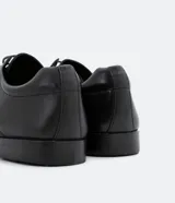 Zapato de vestir negro para hombre, confeccionado en cuero, con cordones y puntera reforzada.